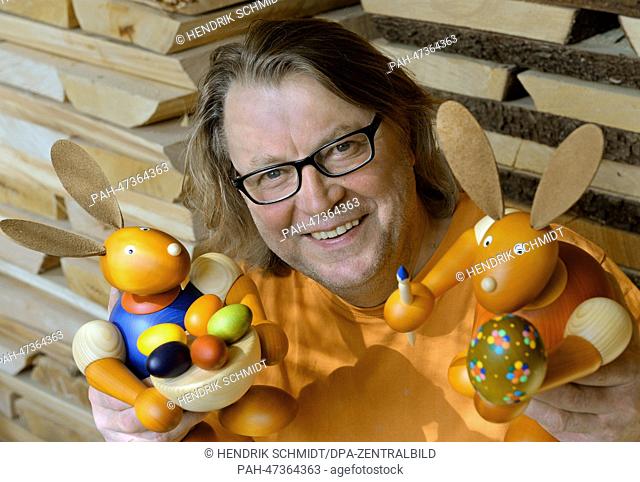 Torsten Martin poses with his wooden Easter bunnies and Easter eggs at the turner's workshop in Eppendorf, Germany, 21 March 2014
