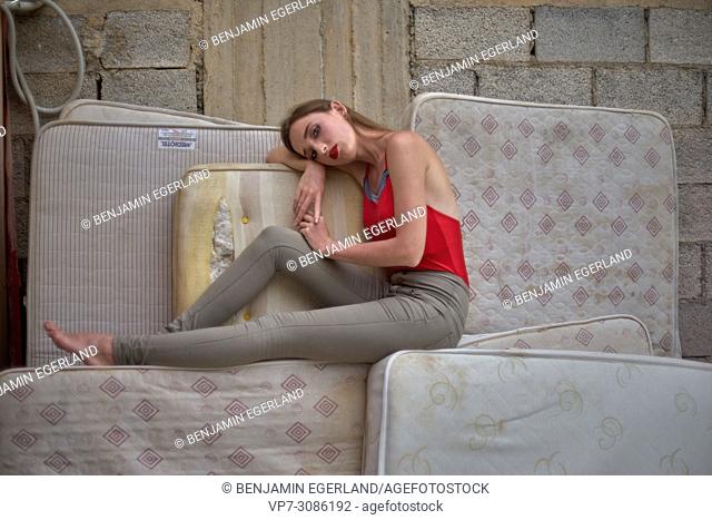 model woman sitting on mattresses, thoughtful, tired, sensual