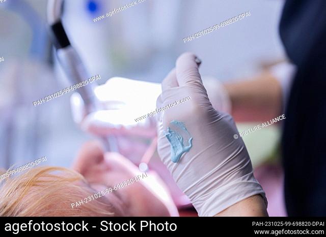 23 October 2023, North Rhine-Westphalia, Mönchengladbach: A dental assistant is cleaning and polishing a patient's teeth in Dr