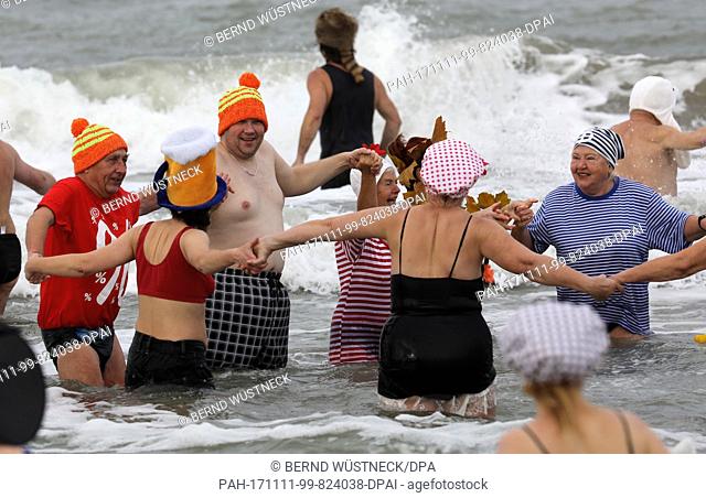 The ""Rostock Seals"" walking in costumes into the 10-degree Celsius waters of the Baltic Sea during the start of the ""fifth season"" at 11:11 in Rostock