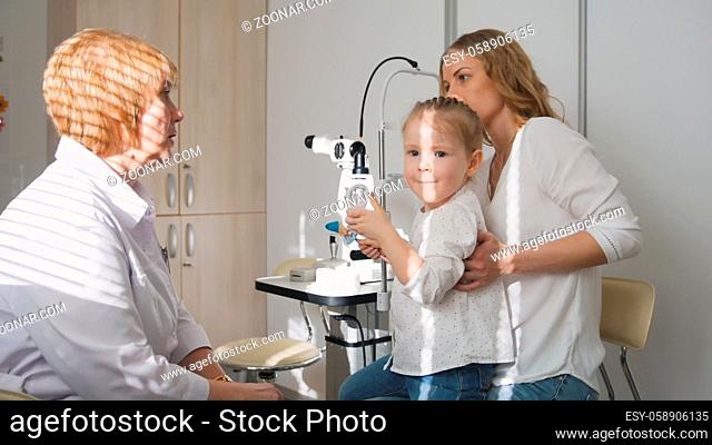 Ophthalmologist in clinic explains diagnosis girl's eyesight, horizontal