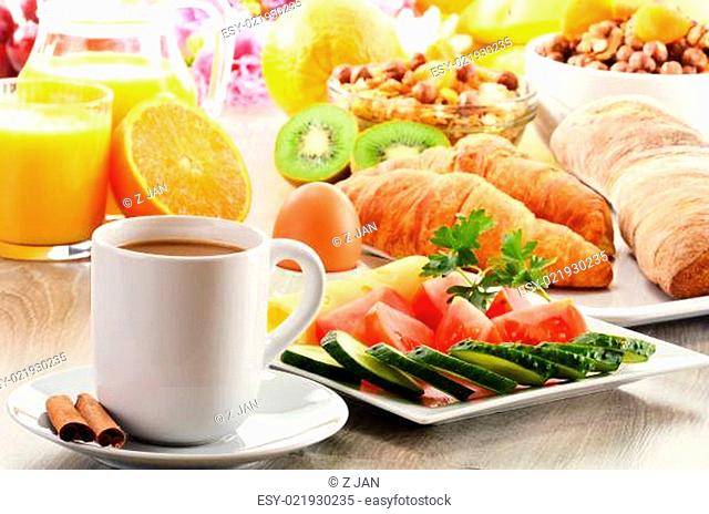 Breakfast with coffee, orange juice, croissant, egg, vegetables