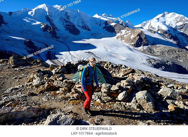Woman hiking with view to Piz Palue (3905 m), Bellavista (3922 m), Piz Bernina (4049 m) and Pers glacier, Engadin, Grisons, Swit