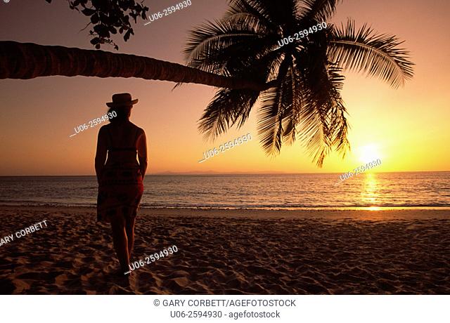 A woman looking at the sunset over the Pacific Ocean at a beach in Costa Rica