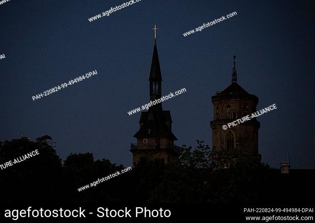 24 August 2022, Baden-Wuerttemberg, Stuttgart: The towers of the Stiftskirche are unlit in the early morning. In view of the threat of a gas shortage in winter