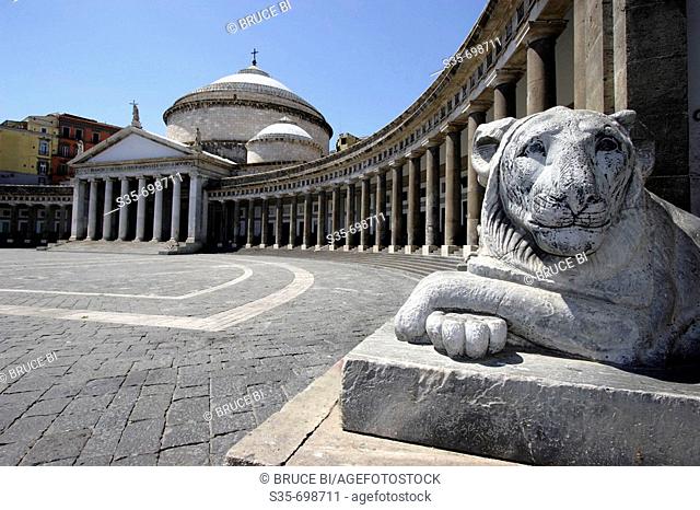 A stone carved lion on the Piazza del Plebiscito with Church of San Francesco di Paola in the background. Naples. Campania. Italy