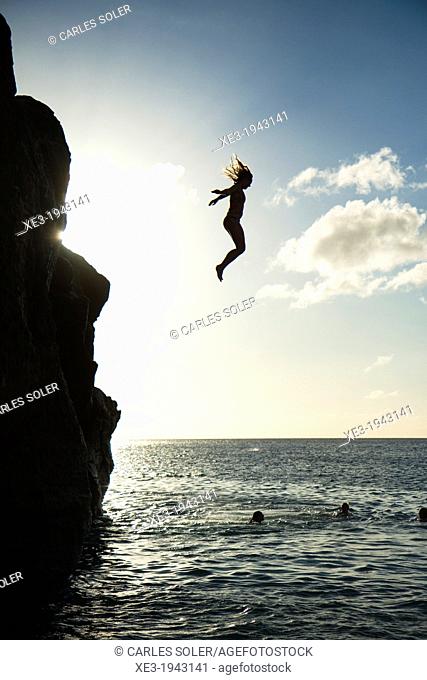 Girl jumping into water, Waimea Bay, Oahu, Hawaii
