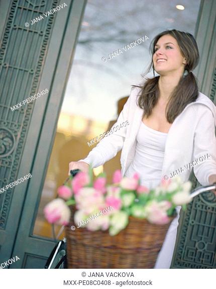 woman on bike with flowers in basket