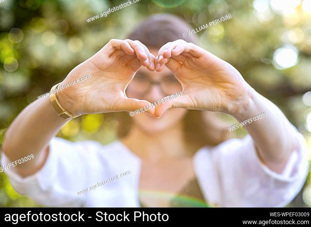 Young woman forming a heart with her hands