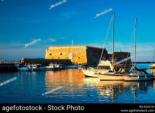 Venetian Fort Venetian fortress of Koules Castello in Heraklion and moored Greek fishing boats in port, Crete, Greece, Europe