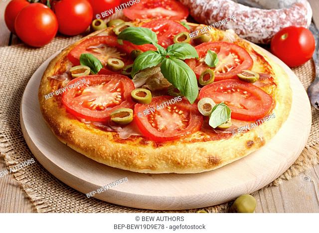 Italian cuisine: pizza with ham and tomatoes. Traditional dish