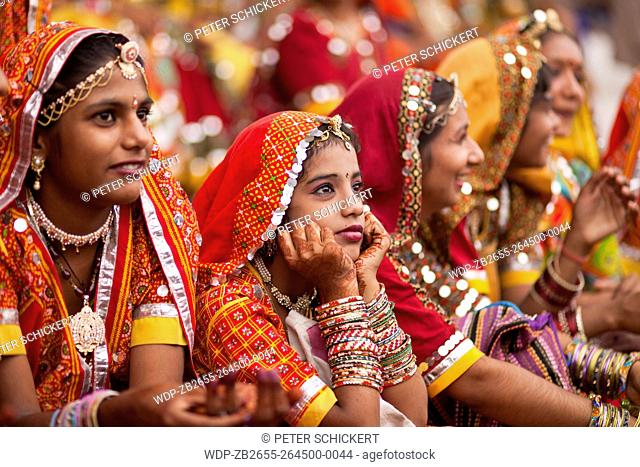Junge Frauen in der typischen farbenfrohen Tracht der Rajasthanis beim Kamel- und Viehmarkt Pushkar Mela in Pushkar, Rajasthan, Indien
