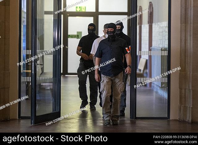 08 August 2022, Berlin: Anis Mohamed Youssef Ferchichi (center, undercover), known by his stage name Bushido, enters a courtroom accompanied by police officers...