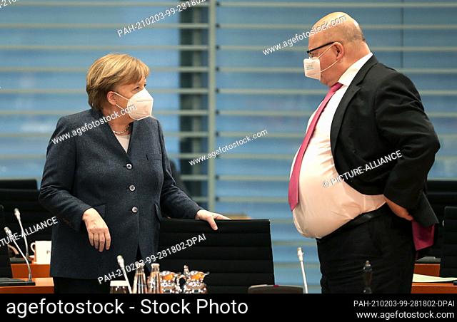 03 February 2021, Berlin: German Chancellor Angela Merkel (CDU, l) talks with Peter Altmaier (CDU), Federal Minister of Economics