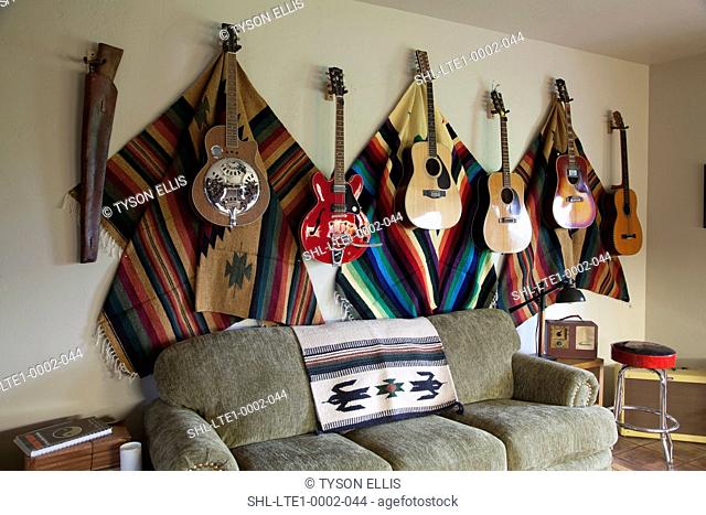 Collection of guitars hanging on wall in western themed living room