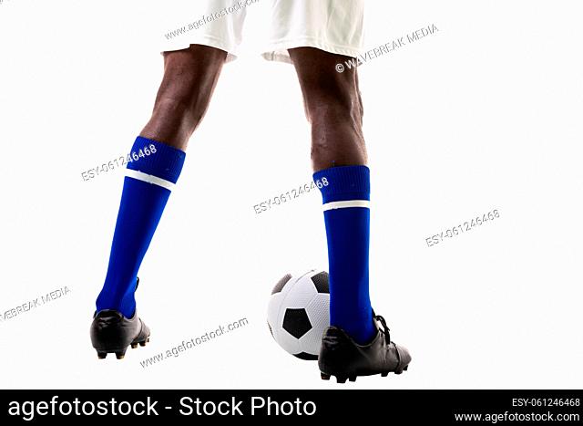 Low section of african american young male athlete with soccer ball over white background