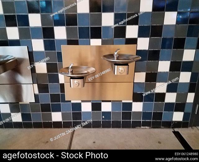 blue and white tiled wall and water fountains