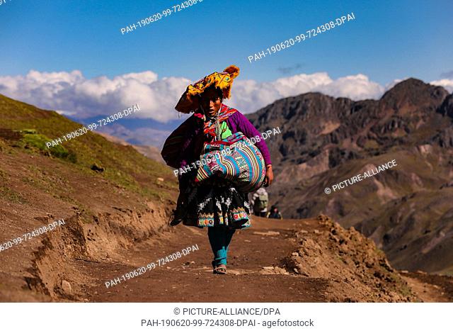 02 May 2019, Peru, Cusco: A woman in traditional clothes climbing up the Rainbow Mountain in sandals Photo: Tino Plunert/dpa-Zentralbild/ZB