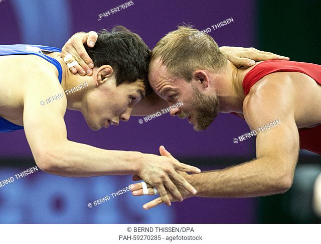 Germany's Marcel Ewald (red) competes with Viktor Lebedev (blue) of Russia in the wrestling Men's 57kg Freestyle Final at the Baku 2015 European Games in the...