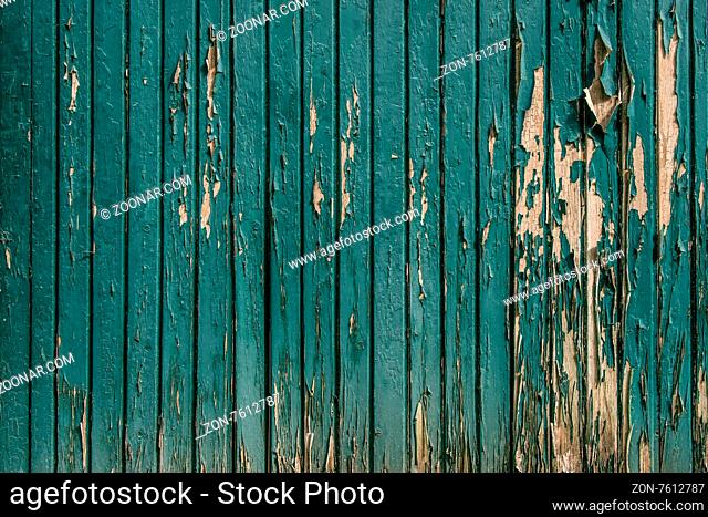 Wooden background with worn paint in teal color