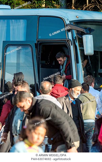 Refugees leave the bus on the Austrian side opf the border between Germany and Austria near Wegscheid, Germany, 28 October 2015