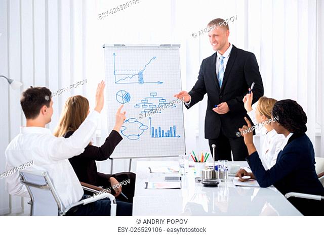 Group Of Businesspeople Raising Their Hands In Conference