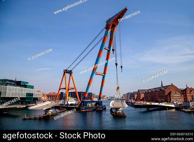 Copenhagen, Denmark - April 4, 2019: The huge Floating Crane Hebo Lift 9 installing parts for a new cycling bridge over the harbour