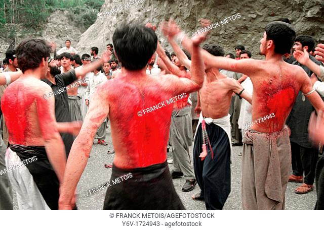 Muslim men flagellating during the festival of Muharram in the Hunza valley, Pakistan. They belong to the shia community