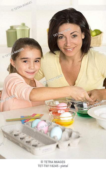 Mother and daughter coloring Easter eggs