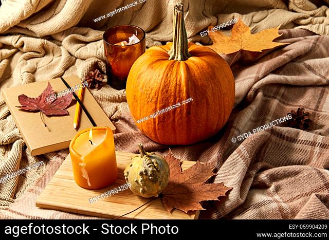 pumpkins, diary, pencil, autumn leaves and candles