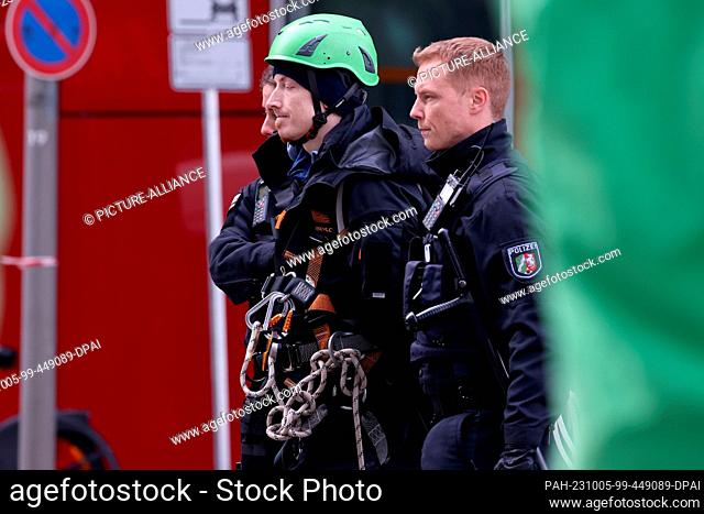 05 October 2023, North Rhine-Westphalia, Duesseldorf: Police officers take away an activist wearing a green helmet during a Greenpeace action in front of Uniper...