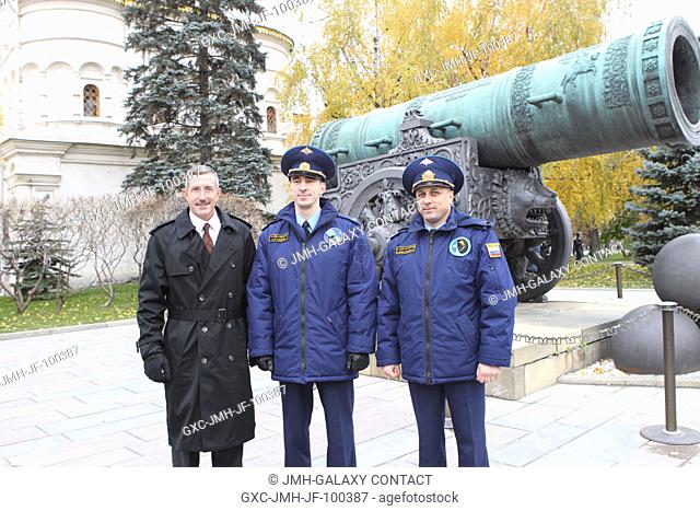 The next residents of the International Space Station pose for pictures in front of the Tsar Cannon at the Kremlin in Moscow Oct