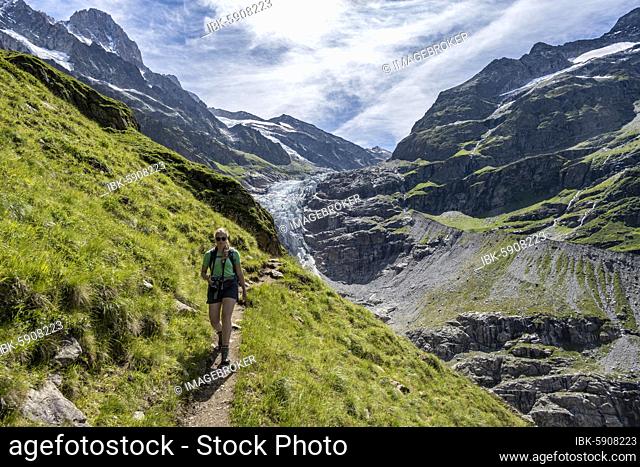 Hiker (right) in the mountains on hiking trail to Grindelwald, left Lower Ice Sea Glacier Grindelwald-Fieschergletscher and summit of Walcherhorn