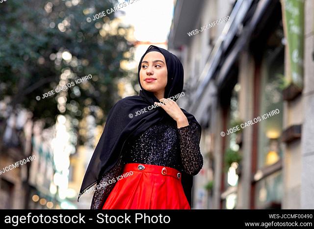 Portrait of young woman wearing black hijab standing outdoors