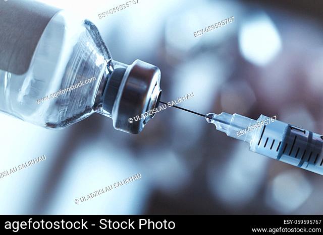 Syringe draws vaccine from ampoule. Coronavirus and flu cure. Close-up view
