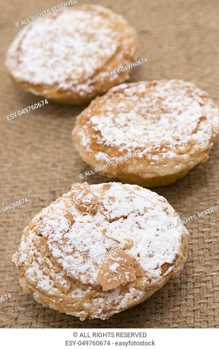Famous Portuguese flaky Bean pastry sprinkled with white sugar powder on hessian fabric