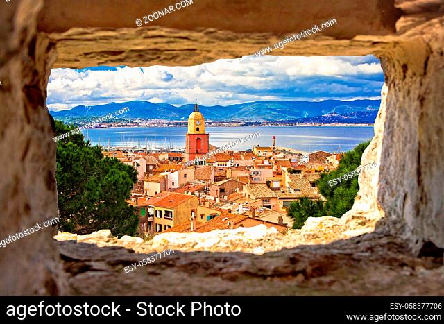 Saint Tropez village church tower and old rooftops view through stone window, famous tourist destination on Cote d Azur, Alpes-Maritimes department in southern...