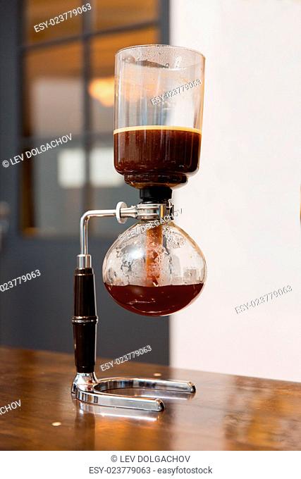 equipment, coffee shop and technology concept - close up of siphon vacuum coffee maker at shop