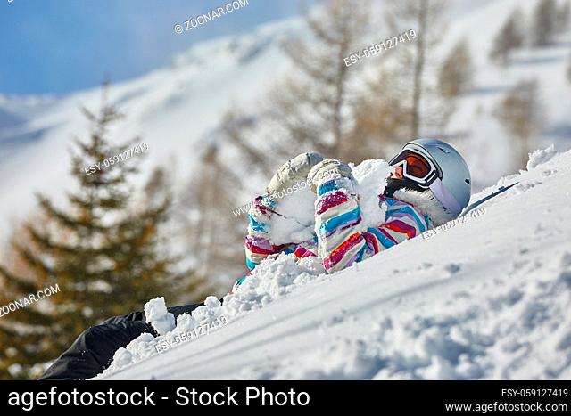 Skier lying in the deep snow playing
