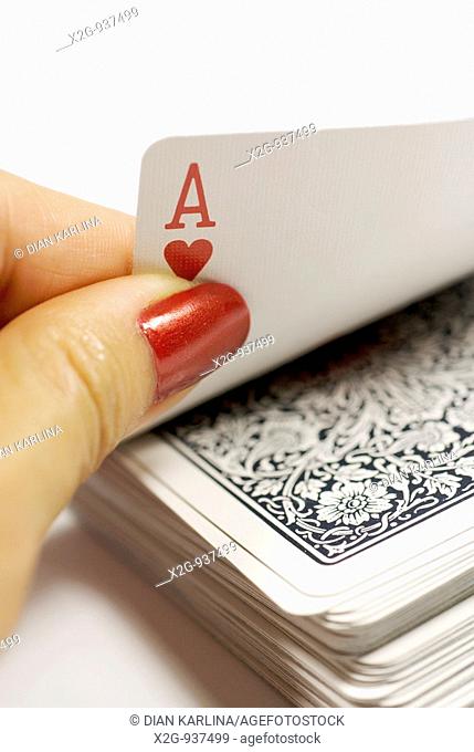 A female hands picking ace from a card stack