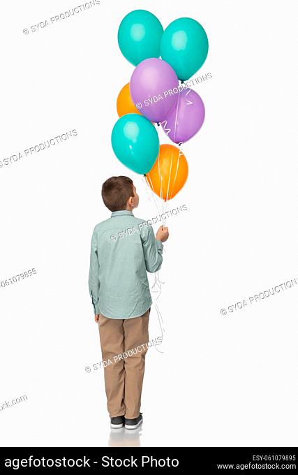 little boy in birthday party hat with balloons