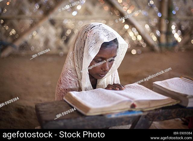 Girl reading in a madrasah, Koran school, camp for Rohingya refugees from Myanmar, Kutupalong, Cox Bazaar, Bangladesh, Asia
