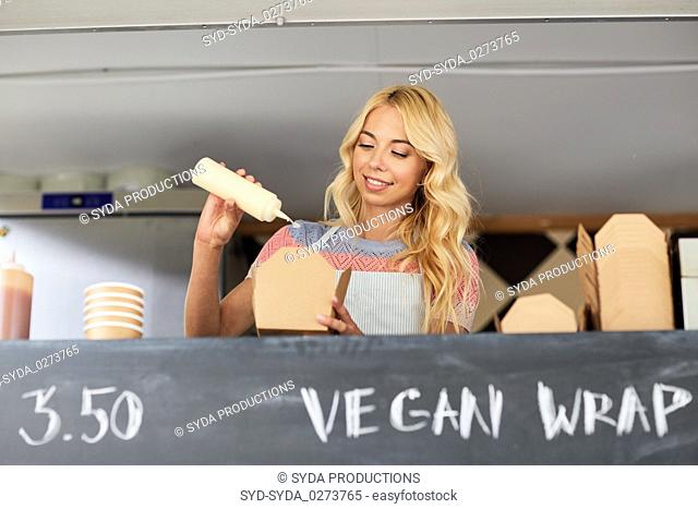happy saleswoman making wok at food truck
