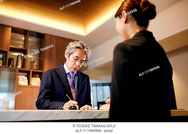 Senior businessman checking in at hotel