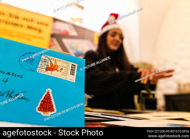 06 December 2022, Baden-Wuerttemberg, Freiburg: Sevilay Catakli, an employee of a postal service provider, cancels a letter with a special St