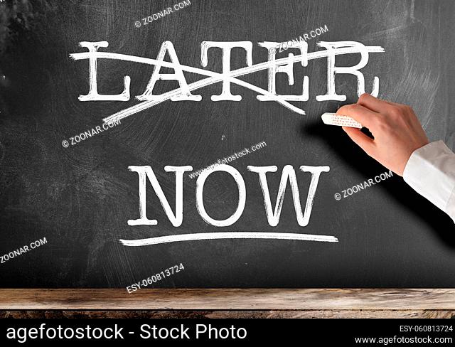 words NOW and LATER written on blackboard with LATER struck out anti procrastination concept