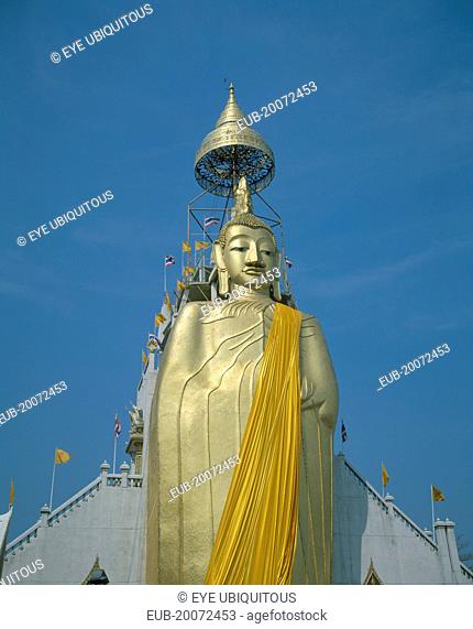 Wat Indrawiharn. Standing Buddha wearing orange sash, containing relic of Buddha from Sri Lanka