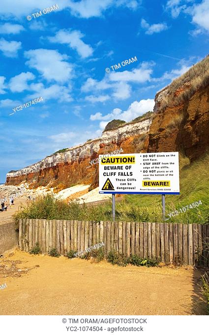 The beach and cliffs with people and warning sign at Hunstanton , North Norfolk , Uk