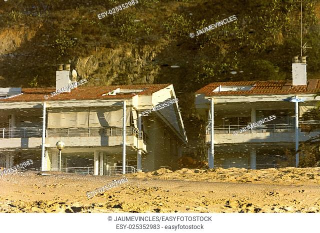 Houses reflected in a puddle on the beach. Caldes d'Estrac, Barcelona province, Spain