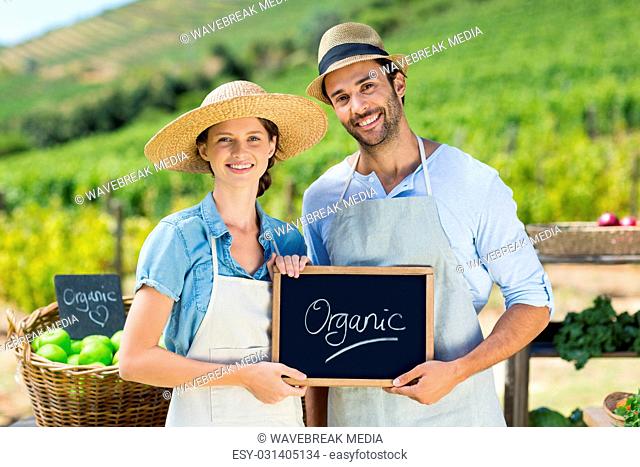 Portrait of happy couple holding chalkboard with text
